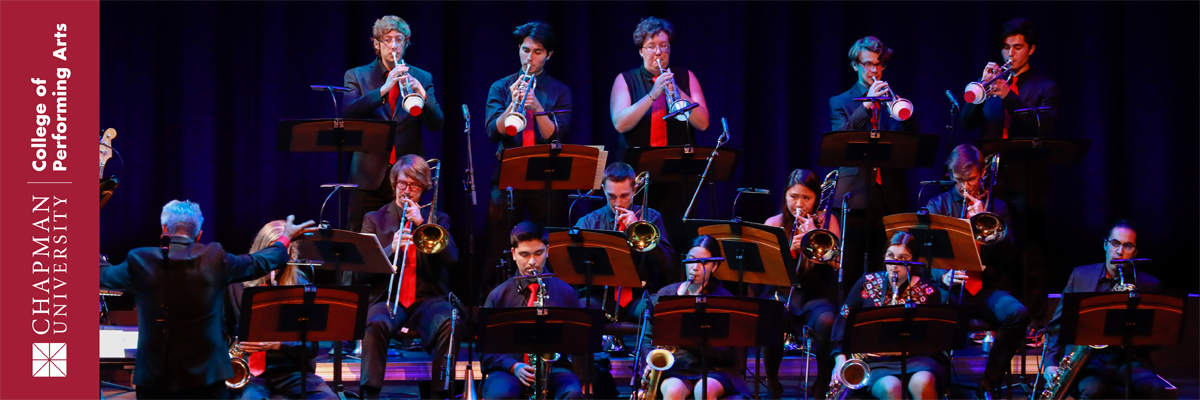 Chapman University College of Performing Arts. A conductor directs a large group of musicians dressed in black shirts and red ties playing brass instruments.