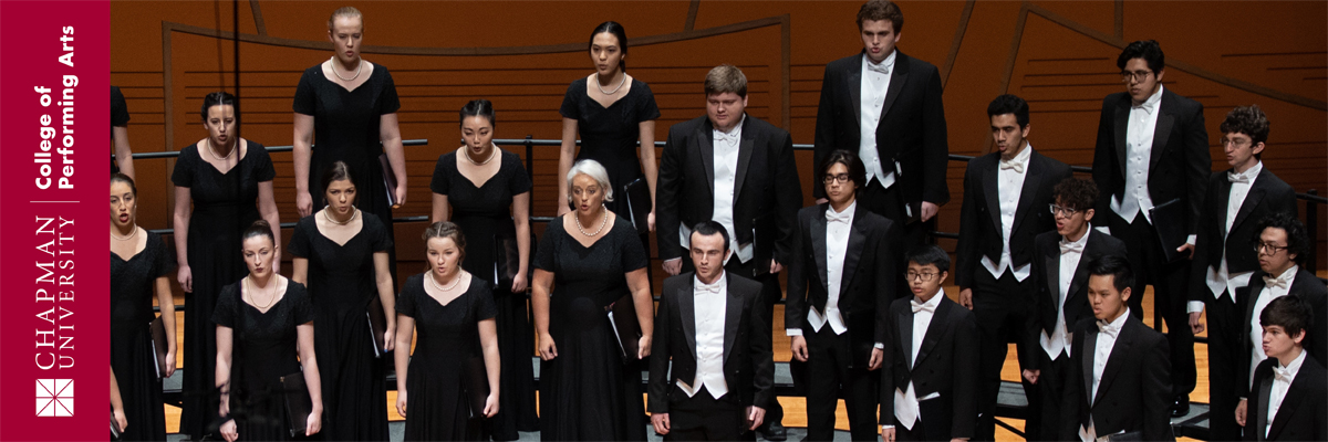 Chapman University College of Performing Arts. A group of choir singers dressed in black formal attire stand on rows of choral risers and sing in unison.