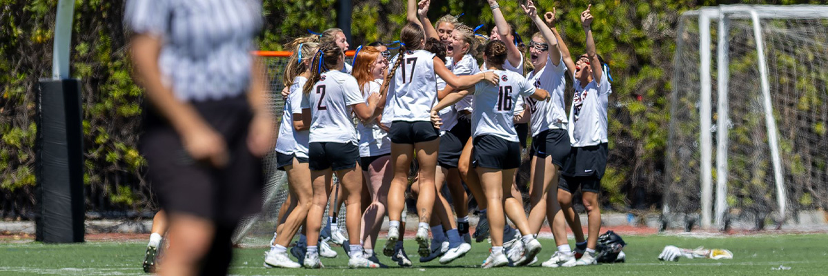 Lacrosse players celebrating in a huddle. 