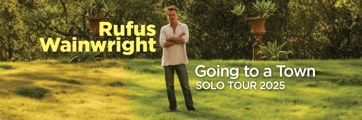 A photograph of Rufus Wainright standing on a lawn.