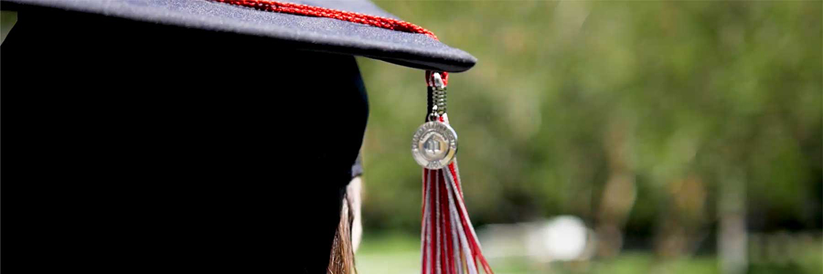 Corner of a graduation cap with a tassel hanging down. 